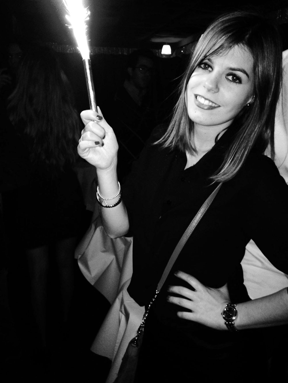 Kelly in her twenties on a night out in Paris, holding a sparkler
