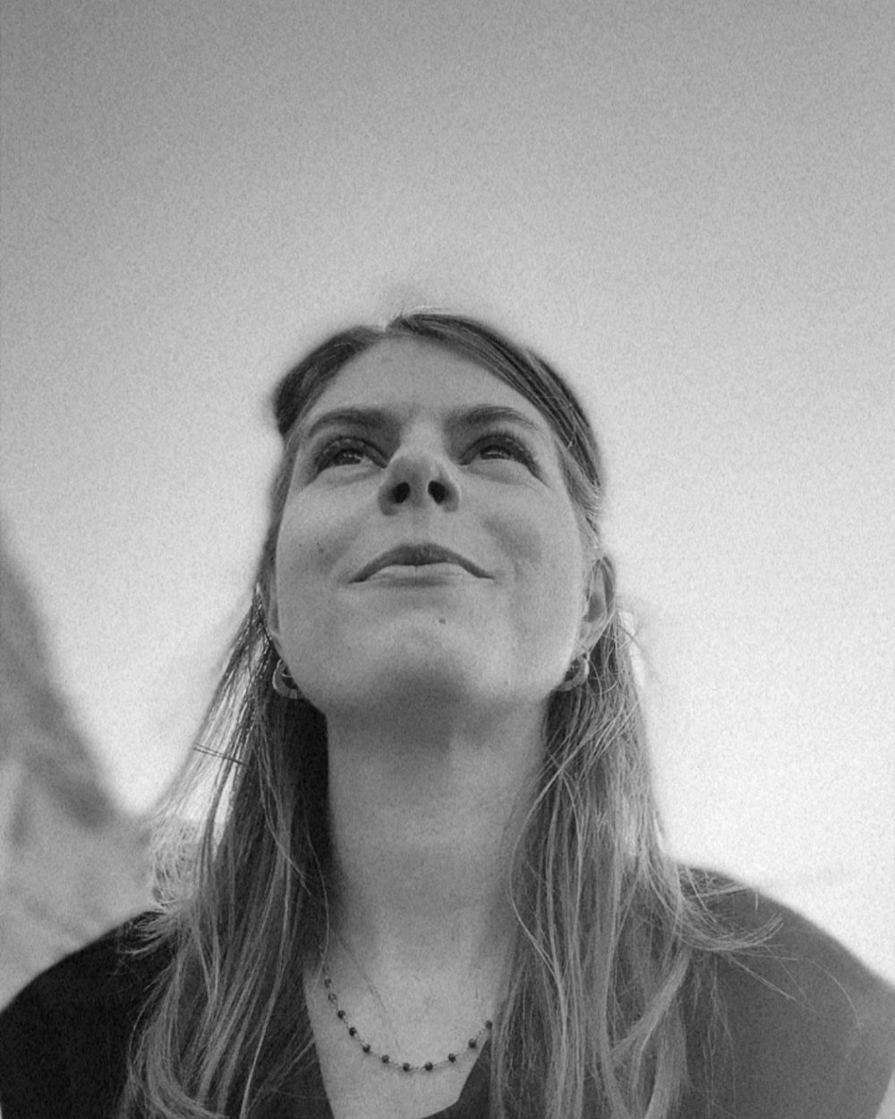 Kelly looking up at the sky with a soft smile